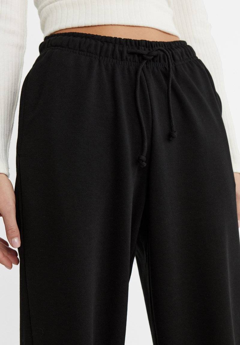 Stradivarius Stradivarius WIDE-LEG JOGGER - Tracksuit bottoms - black Kostenloser Versand international